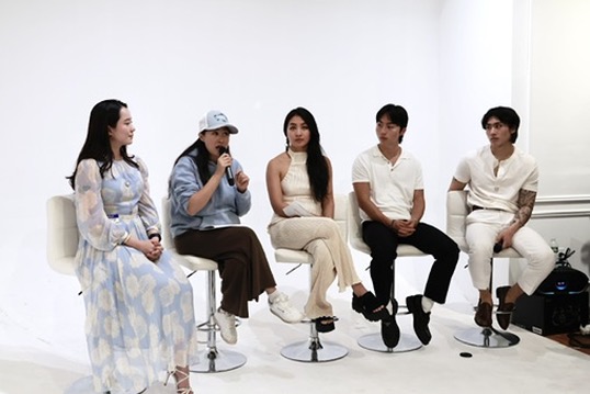 Panel discussion with five seated speakers in a white gallery space