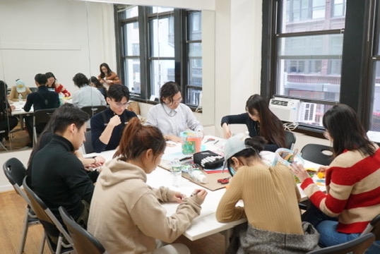 Studio workshop with participants working at a long table